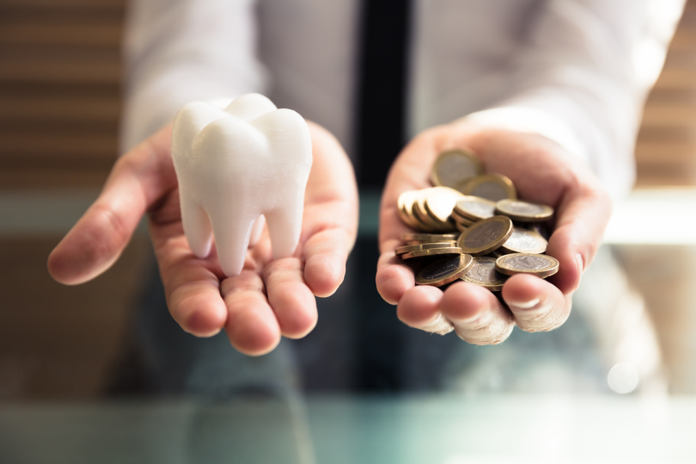 Close up,Of,A,Person's,Hand,Holding,White,Tooth,And,Golden