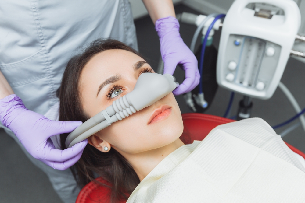 Dentist,Puts,Inhalation,Sedative,Mask,On,His,Patient. Dentist,Puts,Inhalation,Sedative,Mask,On,His,Patient.