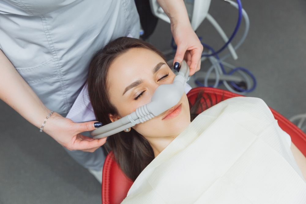 Dentist,Puts,Inhalation,Sedative,Mask,On,His,Patient.
